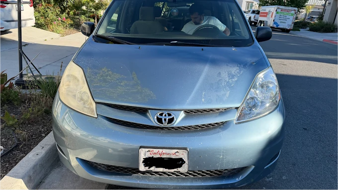 Toyota Sienna on location, mid-job: the driver-side headlight is still yellow and hazy while the passenger-side lens is finished and clear